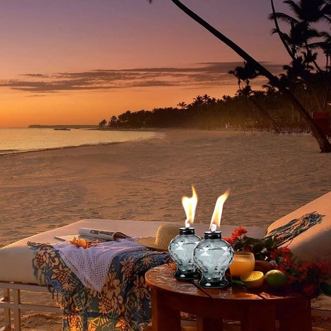 Four Pack Glass Table Top Outdoor Torches With Citronella Refillable Glass Lanterns on table by beach at sunset