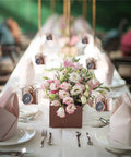 Table setting with pink flowers and 50 Piece Compass Themed Candy Boxes Gift Set For Sweet Treats And Party Favors In Gold And Rose Gold