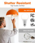 Man installing Eco LED A19 Light Bulb 9W Equivalent To 60W under orange pendant light, highlighting shatter resistance and certifications.