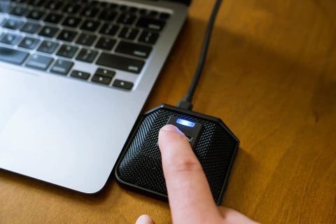 Person using AC 44TAP USB Boundary Conferencing Microphone With Capacitive Touch Mute Toggle next to laptop on wooden desk