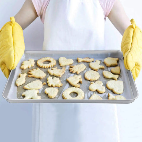 Person holding Stainless Steel Baking Sheet Set with Rack for Oven and Dishwasher Safe 19.6 Inch Two Pans and Two Racks filled with cookies