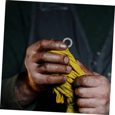 Built Tough Manganese Steel Wedge Locking Washers Heavy Duty Anti Loosening Hardware For Machinery And Construction Vibration Resistant Bolt Stabilizers That Lock Down With Zero Wiggle Room in dirty hands holding yellow cloth.