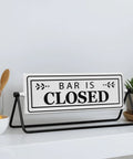 Smooth Flipping Open Closed Sign, Handmade Metal Counter Decor For Your Cozy Home Bar Or Office Coffee Spot With Black Stand And Embossed Lettering Straight Up Real Deal displayed on a countertop with fruit.