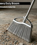 Heavy Duty Angle Broom Featuring Rigid Bristles And An Extended Handle That Smashes Through Stubborn Dirt And Leaves On Patios Garages And Commercial Floors Like Butter on a dirt floor.