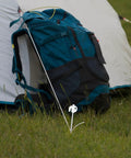 Heavy Duty Tent Stakes Set with Fluorescent Ground Pegs securing a tent with a blue backpack on grassy ground.