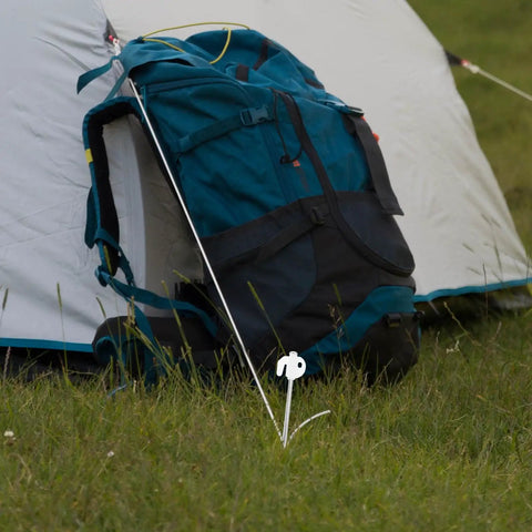 Heavy Duty Tent Stakes Set with Fluorescent Ground Pegs securing a tent with a blue backpack on grassy ground.