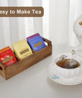 Three Compartment Wooden Tea Bag Box With Handle Acacia Wood Caddy For Tea Bags Sugar Packets Creamers And More next to teapot and cup