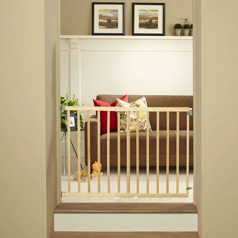 Adjustable Wooden Baby Gate For Stairs From 28 To 42 Inches Wide And 30 Inches Tall installed at the bottom of a staircase