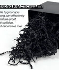 Black crinkle cut paper shred filler spilling from black box, shows One Pound Crinkle Cut Paper Shred Filler For Gift Boxes Baskets And Bags Perfect For Holidays Parties Sub Boxes And Mailers Eco Friendly Recyclable Black Shredded Paper Packaging Filler