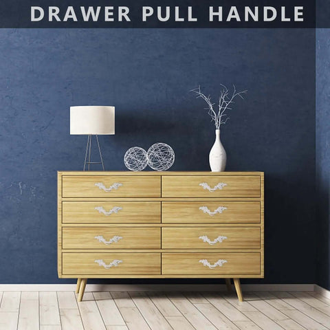 Zinc Alloy Vintage Cupboard Door Handle And Drawer Pull Ring Set In Ivory White For Wardrobe And Kitchen Cabinets displayed on dresser