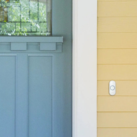 Wireless Doorbell 9 Series With Push Button Blue Grey Portable Chime Adjustable Volume MP3 Download Sleep Mode And Mute 8 Chimes At 90 dB Wall Mount Or Portable Up To 450 Feet Range 5 Year Battery Life installed on wall next to blue door.