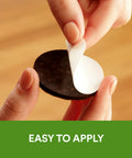 Hand peeling back a brown self-stick pad from Felt Furniture Pads Pack 162 Pieces Round Brown Self Stick Protect Hardwood Floors.
