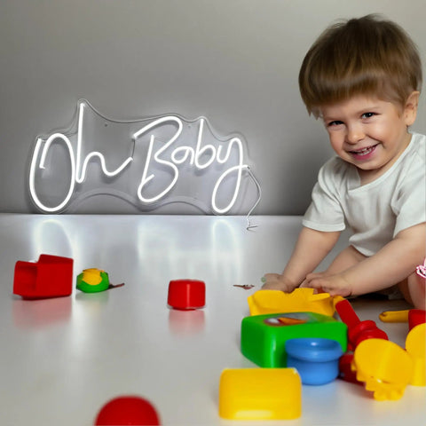 Child playing with toys in front of lit neon sign "Oh Baby" for wall decor, 31.5 by 15.7 inches, dimmable, cool white, for events.