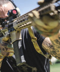 Person wearing Tactical Glove With Anti Slip Grip For Heavy Duty Work, Impact Resistant, And Touchscreen Compatible, Large, MultiCam Camouflage, Freedom Flex Cuff aims rifle outdoors