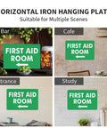 Image showing a green "First Aid Room" sign with left arrow in bar, cafe, entrance, and study settings. Horizontal iron hanging plate.