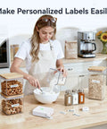 Woman using D110 Upgraded Mini Label Maker With Tape, Pocket Size Bluetooth Thermal Printer in a kitchen to label storage jars.