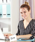 Person working at desk with Set Of 30 Mini Acrylic Sign Holders, 2 X 3.5 Inch Clear Desk Name Plates displayed in the office.