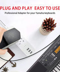 12V 2A DC Power Adapter For Digital Pianos And Portable Keyboards Replacement PA130 PA130B Charger plugged into Yamaha keyboard