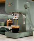 20 Bar Slim Espresso Maker With 1300 Watt Pump And 360 Degree Steam Wand For Silky Microfoam brewing espresso in a glass cup.