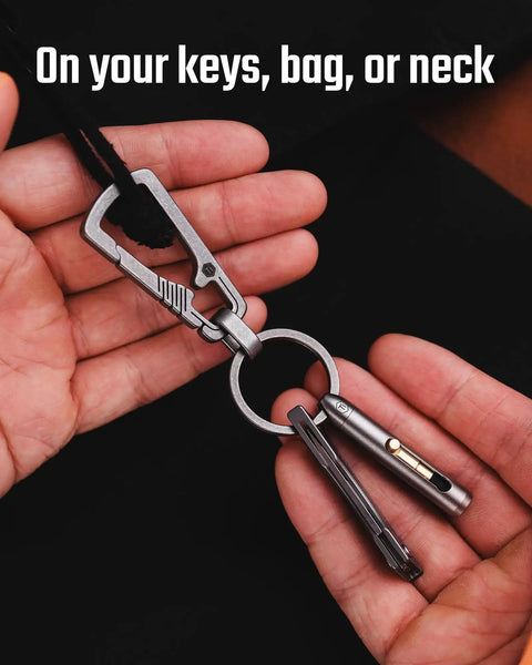 Titanium Mini Infinity Mechanical Pencil Ultra Lightweight Compact Retractable Tip Portable Keychain Writing Tool Includes Two Replaceable Tips For Everyday Quick Notes And On The Go Sketching attached to keychain in hand.