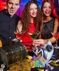 People at a party with a Pirate Treasure Chest Toy with Lock for Kids, coins, and gems, antique brass finish shown on table