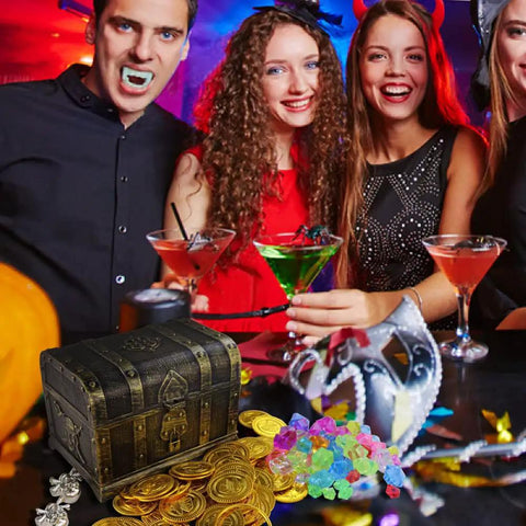 People at a party with a Pirate Treasure Chest Toy with Lock for Kids, coins, and gems, antique brass finish shown on table