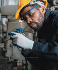 Worker installing Built Tough Rubber Belt Pack For 770 And 900 Continuous Sealers Smooth Transport Feed in industrial setting.