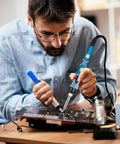 Man using 80W Soldering Iron Kit With Digital LCD Display Pro Grade Adjustable Temperature On Off Switch Fast Heating Thermostatic Design 12 In 1 DIY Solder Gun to work on a circuit board.