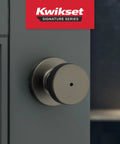 Kwikset Pismo interior round privacy doorknob with lock in gunmetal finish, close-up view