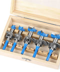 Blue-coated Forstner drill bit set in a wooden box; sizes 15-35 mm labeled along the slots.