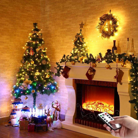 Cozy room with decorated Christmas tree and fireplace, remote for Battery Operated Fairy Lights With Remote, 50 LEDs Warm White, 8 Modes.