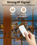Hand holding Remote Control Outlet Switch With Wall Mount, Compact Plug-In Power Control For Lamps And Home Appliances, 300 Feet RF Range, Detachable Wireless Remote, Two-In-One Outlet With Spare Socket, FCC Listed in front of a window during Christmas.