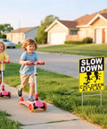 Slow Down Children At Play Safety Signs 2 Pack 17 By 13 Inch Double Sided Corrugated Plastic With H Metal Stakes displayed on lawn.