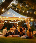29 Feet LED Outdoor String Lights With Shatterproof G40 Edison Bulbs illuminating a backyard gathering under a canopy at night.