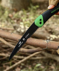 Folding Saw 7 Inch Hand Saw With Pouch D6A M2 Bimetal Blade Pruning and Camping Saw shown cutting a tree branch outdoors.