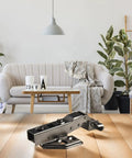 Quiet Close Glass Door Hinge With Hydraulic Dampening System in Black Steel displayed on a wooden surface in a living room.