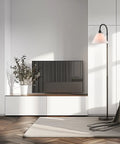Barden 58 Inch Floor Lamp in dark bronze with beige fabric shade placed in modern living room next to a media console