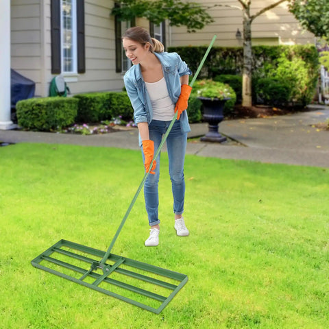 Person using Heavy Duty Lawn Leveling Rake With 180 Degree Adjustable Head And 5.74 Feet Long Handle For Your Yard Backyards Gardens Farms Lawns Rust Resistant Steel Tool For Easy Smoothing And Leveling Of Uneven Soil on a green lawn