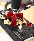 Close-up of Ultimate Cabinet Jig Bundle For DIYers with drilling jig and wood shavings on black and red base