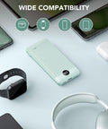 All In One 10000mAh Portable Charger With Built In Micro USB And Type C Cables And AC Wall Plug USB C Power Bank For Phones And Tablets displayed on a desk with various devices.