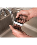 Man using ergonomic nail brush with easy grip handle and tough nylon bristles to clean dirt under running water in sink