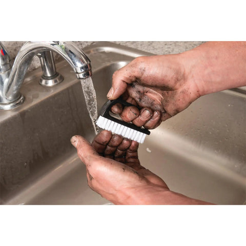 Man using ergonomic nail brush with easy grip handle and tough nylon bristles to clean dirt under running water in sink