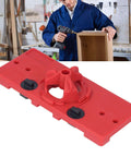 Red plastic woodworking hinge drilling jig for 35mm holes; two black adjustment knobs