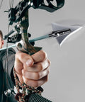 Man aiming compound bow with arrow featuring 125 Grain Fixed Hunting Broadheads With Stainless Steel Blades And Right Bevel.