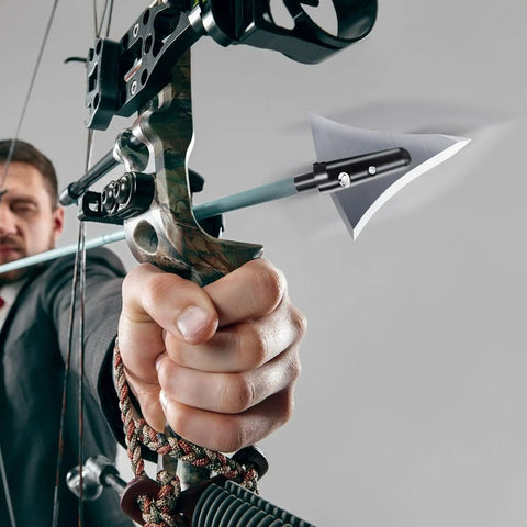 Man aiming compound bow with arrow featuring 125 Grain Fixed Hunting Broadheads With Stainless Steel Blades And Right Bevel.
