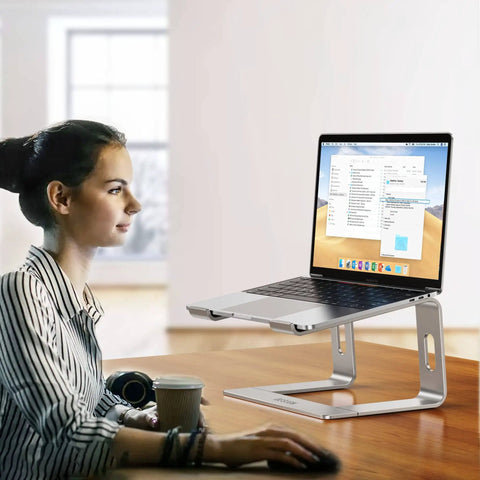 Aluminum Laptop Stand With 6 Inch Elevation, Ergonomic Detachable Notebook Riser, Silver, holding a laptop on a desk with a person using it.