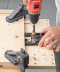 Person using Pro Shop Quality High Precision Woodworking Hole Punch Tool Dowel Jig For Accurate Hole Location In Furniture Assembly And DIY Projects Aluminum Alloy Construction For Long Lasting Performance with drill on wood panel