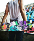 Person holding a skateboard with Street Art Graffiti Grip Tape For Skateboards And Longboards, Bubble Free Anti Slip Deck Sheet 33 X 9 Inches