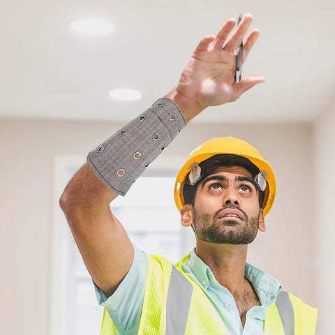 Kick Ass Cut Resistant Wrist Sleeves Breathable Lightweight Arm Guards worn by a worker in a safety vest and helmet, reaching upward.