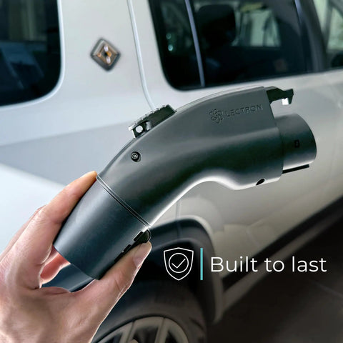 Tesla To J1772 EV Charging Adapter Converter NACS, 48 Amp At 240V held in hand in front of a car